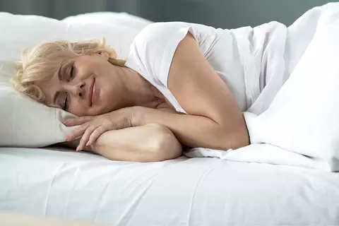 Blonde vrouw slaapt met een glimlach op haar gezicht