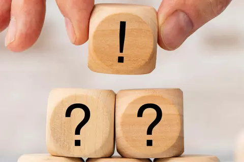 3 houten blokjes, waarvan 1 met uitroepteken en 2 met vraagteken