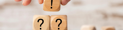 3 houten blokjes, waarvan 1 met uitroepteken en 2 met vraagteken